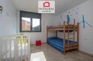 Habitació amb una llitera i un bressol, ideal per les vacances amb nens.